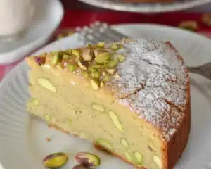 Pistachio Almond Ricotta Coffee Cake topped with pistachios and almond slices.
