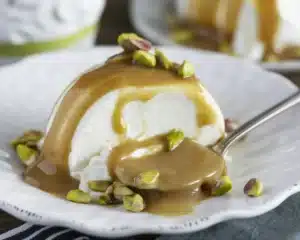 Delicious Pistachio Ricotta Mousse topped with berries and chopped pistachios.