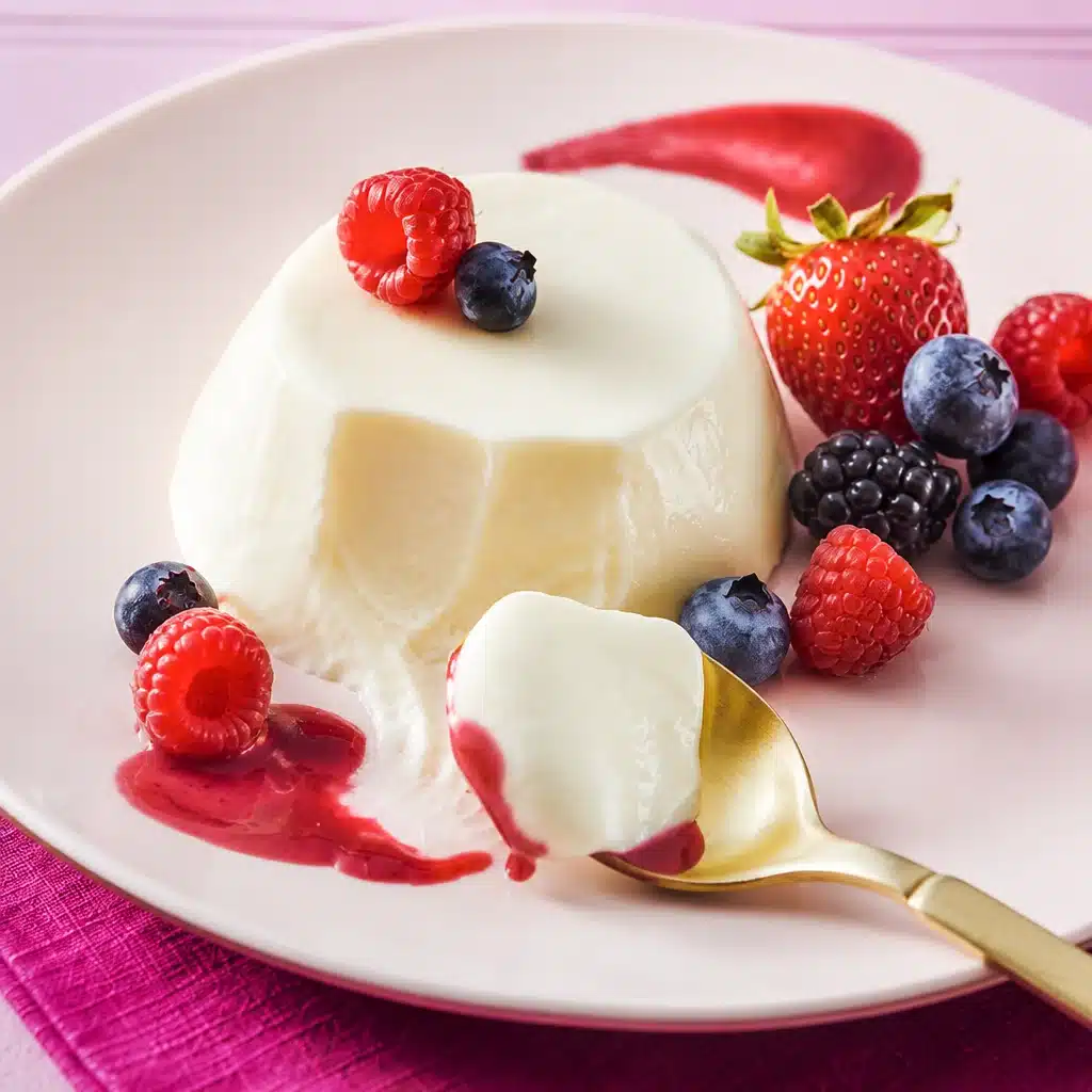 Creamy Vanilla Mascarpone Panna Cotta with a Twist 6 Delicious Vanilla Mascarpone Panna Cotta topped with fresh berries and a mint leaf.